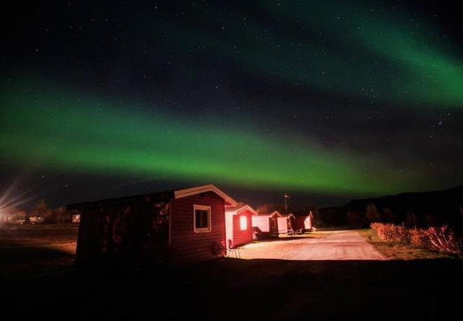 Kaç gündür güneşi görememenin yanında insandan başka canlı da göremedik. Yerden 50 cm aşağıya doğru uzanan ‘permafrost’ denilen donmuş toprak yüzünden Svalbard’da ağaç ve bitki yetişmiyor. Tüm ihtiyaçlar anakaradan geliyor. Yetişen tek yeşiller, yazın görülebilen liken ve yosunlarmış. Bu permafrost yüzünden binaların kanalizasyonları, kablo bağlantıları hep yeryüzünden geçiyor. Hatta binaların temelleri bile yok, hepsi prefabrik. Ayrıca Svalbard’da ölmek yasak, nasıl mı? Burada mezarlık yok. Yıllar önce ölen 35 kişiyi gömüyorlar, hava nispeten ısınıp karlar eriyince ölü bedenler hiç bozulmamış haliyle toprağın üzerine çıkıyor. Bunu görünce bu işten vazgeçip ölüleri Norveç’e götürme kararı alıyorlar.
