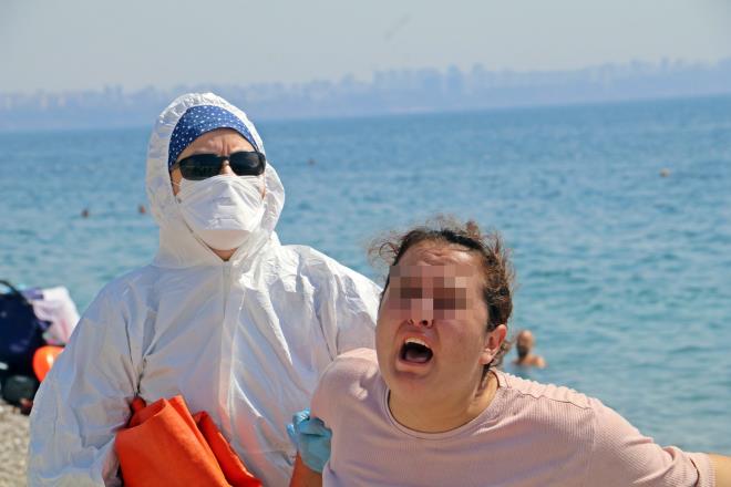 Polisi ve sağlık ekiplerini alarma geçiren olay dünyaca ünlü Konyaaltı Sahili’nde 10.30 sıralarında meydana geldi. Edinilen bilgiye göre, çocuğuyla birlikte sahile gelen Dilek M. (31), yanındaki bavulda bukunan eşyaları etrafa saçmaya başladı. Bu sırada, ‘hastayım, ölmek istemiyorum’ diye bağıran Dilek B., iddiaya göre sahilde etrafa tükürmeye başladı.