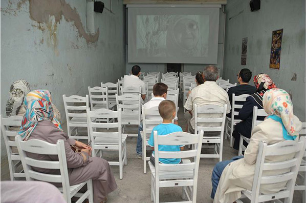 Salonun duvarlarında o döneme ait "Bruce Lee, Belmando, Maceracılar" afişleri dikkat çekici...