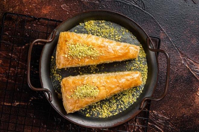 Ustaca kesme işlemi gerektirmeyen ama lezzeti en ala ustaların yaptıklarını aratmayan Havuç Dilim Baklava Tarifi...<br>  Yufkalarınızı yuvarlak borcam boyutunda kesin ve yağlanmış borcama ikişer ikişer baklava yufkalarını aralarına kestiğiniz parçalar olacak şekilde dizin. Yufkanın yarısı bittiğinde arasına kırık cevizleri ekleyip tekrar yufkalarınızı dizin ve üçgen şekilde kestiğiniz baklavayı önceden ısıtılmış 170 derece fırında üzeri kızarana kadar pişirin. Sıcak baklavaya soğuk şerbeti gezidirin ve dinlendikten sonra üzerine toz fıstık serperek servis edin.