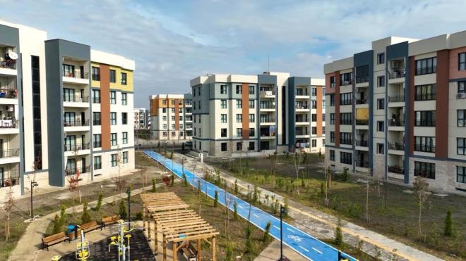 ÖZEL BİR BAŞVURU SİTESİ OLACAK    7 bölgede projemizi yapıyoruz. İstanbul'da 100 bin konut yapıyoruz. Yerleri konusunda çalışıyoruz. Bu konutların hepsi bizim deprem dönüşümü için attığımız önemli bir adım olacak. Konya'da 13 bin, Ankara'da 30 bin konut yapıyoruz. İzmir'de 21 bin 520, Antalya'da 13 bin konut yapacağız. Hatay'da deprem konutlarına ek olarak 12 bin konut yapacağız. Biz proje bölgelerinde mahalle konakları da yapacağız. Sosyal donatılar da olacak. İçinde taziye evi olacak vatandaşlarımızın iyi gününde kötü gününde kullanabilecekleri. 500 aile sağlığı merkezi yapacağız. 500 gündüz bakımevi yapacağız. Spor salonumuz var. Lüks sitede olması gereken ne varsa olacak. Misafirhanelerimiz olacak. 500 konutta bir tane de bunlardan olacak. Apartmanda herkesin ne sorunu var ne sıkıntısı var bilirdi. Biz o ilişkiler yaşasın istiyoruz ve bu bakış acısıyla da zemin artı dört katı geçmeyeceğiz. Türkiye'nin yine en iyi mimarlarıyla artık bunu yaparken de yani deprem bölgesinden şu iki yılda yaptığımız tecrübeyi bu projeye yansıtıyoruz. Eksiklerimiz varsa o eksiklerimizi gideriyoruz. Yani burada en önemlisi sağlamlık, depreme dayanıklılık ve onunla birlikte de gerçekten insanımızın huzur içerisinde yaşayacağı projeler. Burada verimli bir şekilde bu projeleri yapmaya gayret gösterdik. Yine baktığınızda 2 + 1 65 ve 80 metre² daireler bunlar.