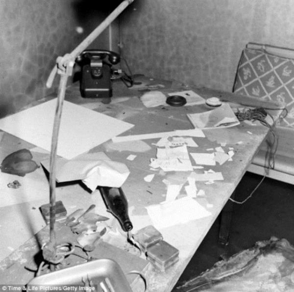 Kanepenin yanndaki derme atma masann stnde Hitler&#8217;den geriye kalan eyalar grlyor. Bu fotoraflar ilk defa William Vandivert tarafndan Hitler&#8217;in lmnden iki hafta sonra ekildi.