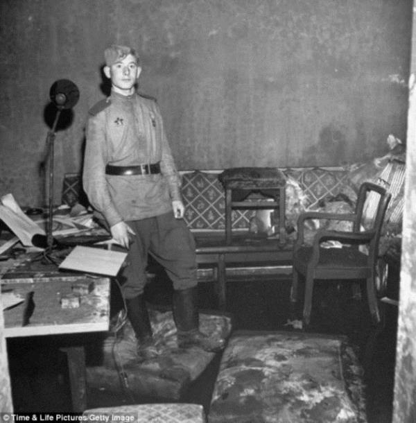 Snan bir dier odasndaki molozlarn arasnda, yrtk ve yanm kanepenin nnde bir Rus askeri.