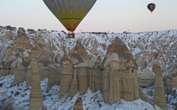 Greme beldesinden havalanan balonlardan "beyaz Kapadokya"y izleyen turistler, gnein douunu takip etti.