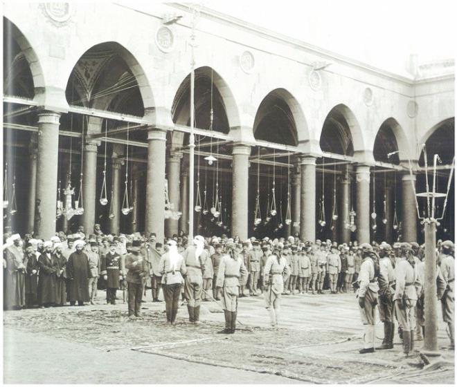 Subay, asker ve ehir erafnn katlmyla Harem-i Nebevi&#8217;nin avlusunda yaplan bir trende Fahreddin Paa, gsterilen kahramanlktan tr bir alay sancana nian takarken grlyor. Paa, Medine&#8217;de bulunduu srada resmi yazmalarda askerleri iin &#8220;Mehmetik&#8221; tabirini kullanmakta ve onlar Peygamber&#8217;in askerleri olarak nitelendirmekteydi. Zira ngiliz oyunlaryla, bedevilerin isyanlaryla, alkla, susuzlukla, 50 dereceyi aan kavurucu scakla, bata spanyol Nezlesi ve askerin dilerini ve enesini dren skorpit olmak zere trl hastalklarla ve ar l koullaryla canla bala mcadele ederek Medine-i Mnevvere&#8217;yi, Hz. Peygamber&#8217;in kabrini son ana kadar savunan, teslim arlarn geri eviren Fahrettin Paa&#8217;nn bu dik duruu ancak ve ancak Peygamber sevgisiyle izah edilebilir.