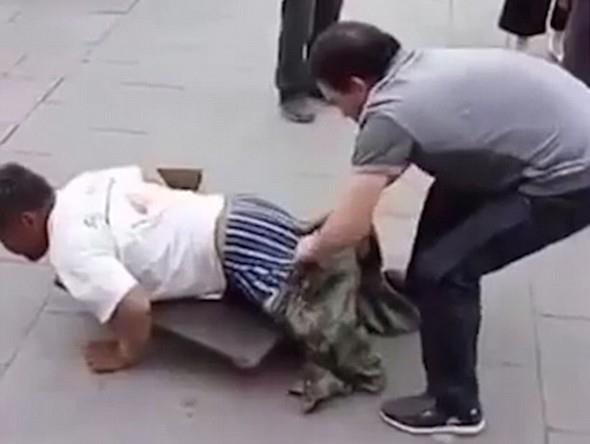 in'de bir adam ayaklar kesilmi gibi grnen dilenciye yaklap dilencinin gerekte ayaklar olduunu gstermek iin dilencinin pantolonunu kard.
