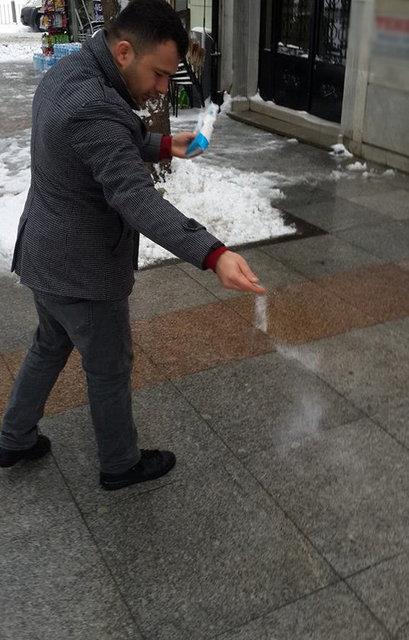 stanbul'da bir esnaf i yerinin nndeki karlar temizledikten sonra kapsnn nne sofra tuzu dkt.