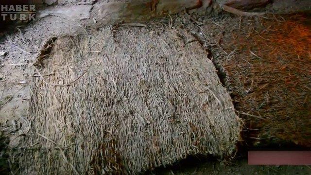 Yamurlu havalarda, nemlenen yerden korunmak iin yapt hasrlar, daha nce sfrdan yapm olduu kulbenin yzeyine seriyor...