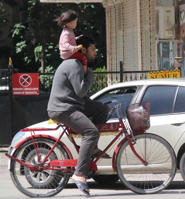 Adana'da hayrete dren grntler kameraya yansd.Baba kk kzn omuzuna alp bisiklet srd.