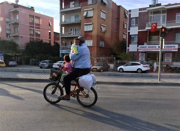 3 kiinin bindii ocuk bisikletini dengede tutmaya alan src kendi ile ocuklarn canlarn tehlikeye atarak grenlerin akn baklar arasnda yolculuuna devam etti.