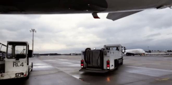 Uak piste indiinde kk bir araba uan alt blmesine yaklaarak, hortum yardmyla tm atklar tahliye ediyor.