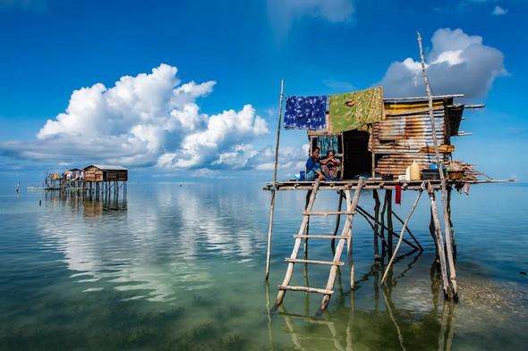 Milliyetleri ve topraklar yokBajau Su ingeneleri, younluklu olarak Pasifik Okyanusu&#8217;nun bat kysnda, suyun zerine kurduklar kylerde yayorlar. Yazl bir tarihleri yok. Hikyeleri nesilden nesile anlatm yoluyla geiyor. Birka yzyl nce, ilk yaadklar yer olan Filipinler&#8217;den kovulup, ev olarak kullandklar teknelerle, Malezya&#8217;ya ait bu kylara geliyorlar. Bir milliyetleri yok, topraklar yok! Zamanla adalardan kestikleri aalarla okyanus zerinde elverili bulduklar yerlere evlerini ina ediyorlar. Yllar iinde bir ksm karaya yerleiyor, halka karyor, eitli iler buluyor kendine. Kalanlar, says 40-50 civarnda olan kylerde, akl almaz gzellikteki bir suyun zerinde, d dnyadan olduka kopuk, kurallarn okyanusla birlikte belirledikleri benzersiz bir hayat yayorlar. Din yok, devlet yok, eitim yok! Hatta yalar bile yok! Hayatlaryla ilgili kstlayc bir zaman sayacna ihtiya duymamlar. Malezyallarn dahi anlayamad, kendi dillerini konuuyorlar.