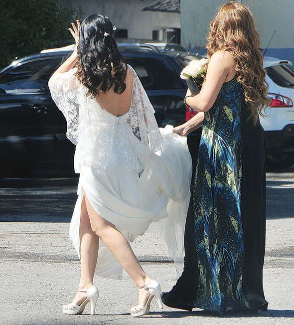 Fotoraf ekimi srasnda Sinem Yalnkaya&#8217;ya yardmc olan arkada, gelinliin kuyruk ksmn kirlenmesin diye elinde tad.