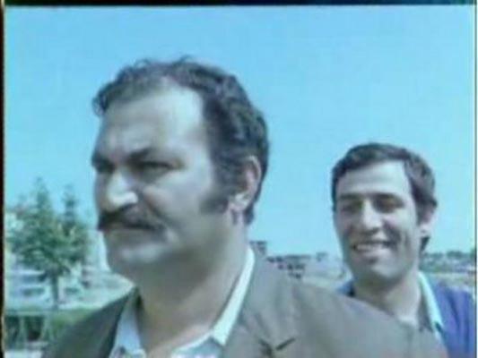 SAKAR AKR-  KEMAL SUNAL, UMUM TUVALET SIRASINDA NNDEK ADAMIN APKASINA YOR VE ADAM APKAYI KAFASINA GERNCE SIRILSIKLAM OLUYOR. HEMEN AKR' KOVALAMAYA BALIYOR ANCAK ZER KUPKURU.