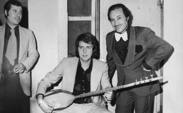 Bir gazino kulisi. mit Tokcan, yine sazn eline alm, ayn gazinoda sahneye kan arkada Mustafa Sayaar'a yeni derledii trksn dinletiyor (1976).