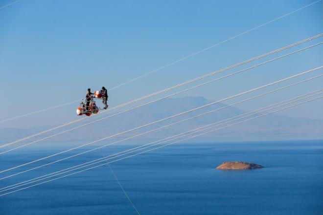 Van ile Siirt arasnda elektrik aktarmn salayacak yksek gerilim hattnda alan iiler, yerden metrelerce ykseklikte tel ve direklerin zerinde bir ok riski gze alarak ekmek mcadelesi veriyor. zkan Bilgin