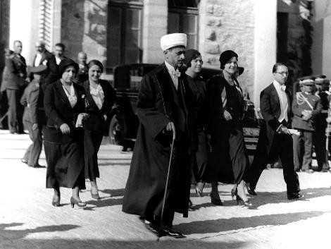 FRAKLI DN ADAMI  <p>    ekim tarihi bilinmeyen bu fotorafta yryenler, Atatrk&#8217;n davetlileri. &#8220;Kemal Paa&#8217;nn ylda bir lkenin nemli isimlerini kabul ettii bir gnde, lkenin nde gelen din adam bile Avrupa tarz frak giyiyor&#8221; notu dlm ariv kaytlarna. Ankara&#8217;da ekilmi fotorafta askerler duruyor duvarn dibinde ve bir de araba. Diyanet leri&#8217;nin ilk bakan Rfat Breki&#8217;nin yardmcs olan ve daha sonra da Diyanet leri Bakanl&#8217;n stlenen Ahmet Hamdi Akseki nde. En sada protokol mdr, arkada kordiplomatik.  <p>    FOTORAF: KURT VE MARGOT LUBNSK