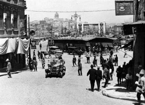 Fotoraf, Eminn Yeni Cami basamaklarndan 1928&#8217;de ekildi. Bugnle kyaslandnda o kadar byk farklar var ki... nsan ok az ama hepsi gayet k... Neredeyse herkes takm elbiseli... Birka ara ve at arabas yayalarn arasndan farkl ynlere gidiyor... Belli ki yeni yeni olumaya balayan trafik doalama akyor... Fotoraflar: Maynard Owen Williams