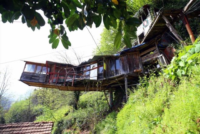 Arazi yapsndan kaynaklanan sorunlara vatandalarn farkl zmler retmesiyle dikkati eken Rize, neredeyse her ilesindeki ilgin evleriyle ziyaretilerini artyor. Gneysu ilesine bal Grgen kynde yaayan Bilal Atasoy da kayalara elik halatlarla balad evinde yaamn srdryor. Yllar nce arazisindeki yamata bulunan byk kaya ktlesini oyan Atasoy, bu alana 6 metrekarelik tek odal ahap yap ina etti. Atasoy, evini salamlatrmak iin elik halatlarla evredeki kayalara balayarak farkl bir yapya imza att.