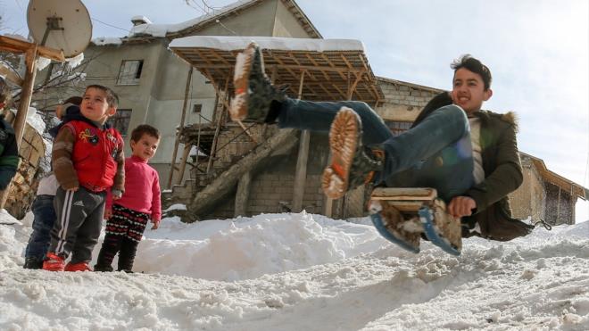 Tahtadan yaptklar kzaklarn karda daha hzl gitmesi iin altna plastik su borular takan ocuklar, gn iinde defalarca mahalledeki tepeye trmanp, kayyor.