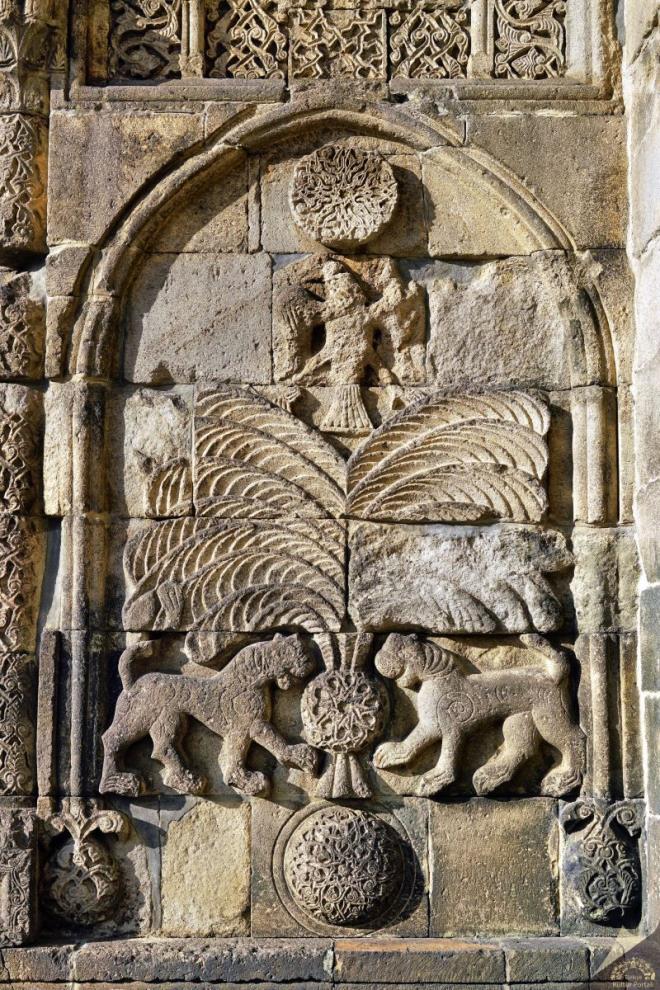 Ta kapnn yan yzlerinde, silme kemerle evrili niler iinde pars ve kartal motifleri dikkat ekmektedir. Ajurlu bir kreden kan hurma yapraklar, iki pars ve kartal figrlerinden oluan hayat aac Orta Asya Trkleri'nin nemli simgelerini bir araya getirmektedir.