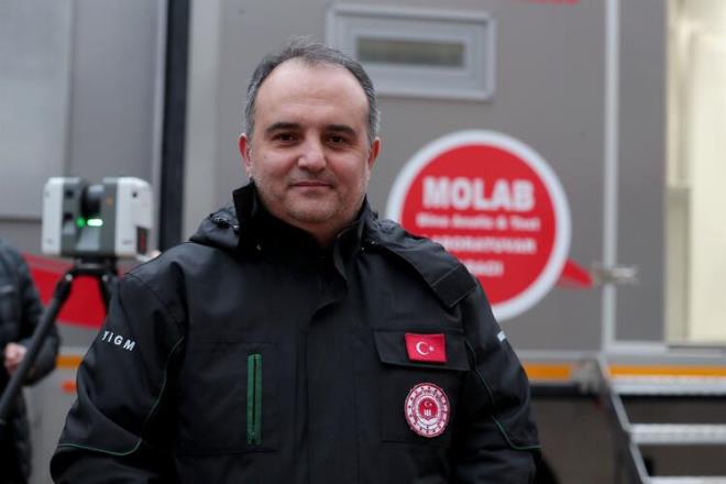 "Burada bu cihaz kullandk ve gerekten ok faydasn grdk. Bu cihaz lazer tarayc cihaz. 130 ile 150 metre yar apnda bulunan btn binalarn noktasal, konumsal olarak btn verilerini saniyede 2 milyon at yaparak kendi beyninde data alyor ve daha sonra biz bu blgelerde 15 dakika, yarm saat sonra deiik lmler yine yapyoruz. eitli alardan ald o verileri, arataki bilgisayarda st ste koyuyoruz. Acil yklacak binalar, arama- kurtarma yaplan enkazlarn yanndaki dier binalar yerinde lerek, insanlarn zerine devrilmeden nce bu cihazn verdii risk durumuna gre biz srekli kontrol altnda tutuyoruz. Cihazn kendi iinde USB sistemi var. Bu sistemi biz aracmzdaki bilgisayara aktaryoruz. Bilgisayarda yapm olduumuz dier almalarla hepsini st ste getiriyoruz."