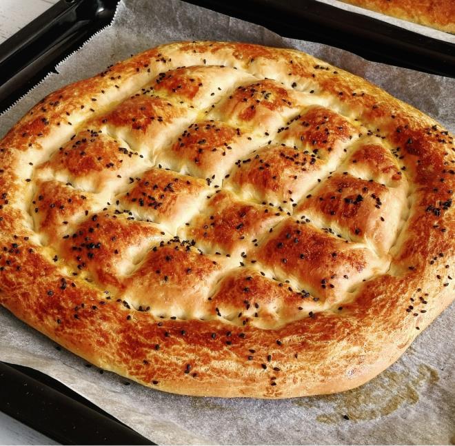 RAMAZAN PDES TARF YAPILII  <br>  1. Derin bir kaba maya, st ve eker ekleyip, maya eriyene kadar 10 dakika bekletin.  <br>  2. Ardndan dier malzemeleri de ilave edin. Hamuru yourun ve kvama geldikten sonra zerine nemli bir bez kapatarak 40 dakika mayalanmasn bekleyin.  <br>  3. Hamuru paralara ayrn.  <br>  4. Tezgha un serpin ve her paray alp elinizi de unlayarak an ve istediiniz ekli verin.  <br>  5. Atnz hamuru yaladnz veya yal kat serdiiniz tepsiye yerletirin.<br>    6. Elinizi unlu sulu karma batrarak nce kenar ksmlarna sonra orta ksma iyice bastrarak klasik pide eklini verin.<br>    7. Hamuru yarm saat mayalanmas iin bekletin ve tekrar ekil verdiiniz ksmlarna nce yaptnz ilemi uygulayn ve atal yardmyla delikler an.<br>    8. stne sos srn. Ardndan susam, rek otu serpin ve nceden stlm 200 derecede kzarana kadar piirin.