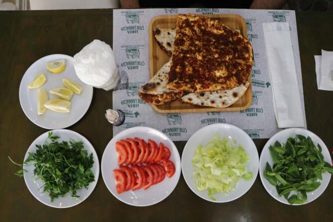 ANLIURFA'DA LAHMACUN KURU SOANLA YAPILIR<br>    Lahmacunu soanl tercih eden anlurfa'da ise hem alar hem vatanda en lezzetlisinin byle olduu grn savunuyor. Restoran iletmecisi Mehmet nan, "Lahmacunu sarmsakl yapanlar var, soansz yapanlar var, etsiz yapanlar var. Ancak anlurfa&#8217;da kuru soan ve etle yaplr. Urfa&#8217;daki lahmacunun zellii soanl olmasdr. Lahmacunda biz kuzu eti kullanrz. Soan younlukta oluyor. Bizde kuru sarmsak ok az koyarz. Ardndan en son ise maydanoz ve baharat ekleriz. Baharatta da en nemli olan Urfa isotudur. Hepsi harmanlanarak lahmacunun ii hazrlanr. Piiminde ise ince hamur odun ateinde pier. Bizim Urfa lahmacunu tr olur. Doalgazl frnlar var ancak olmazsa olmaz odun ateidir. Urfa lahmacunu dier lahmacunlara gre ok daha ince olur. Bylelikle tr ve gevrek olur. Lahmacunumuz soanl olduu iin tekrardan yannda soan vermeyiz. Onun yannda maydanoz, nane, limon, domates ve pimi patlcan servis ediyoruz" diye konutu.