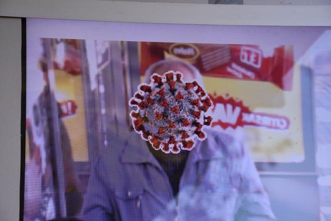 Gvenlik kameralarna yansyan grntlerde, duraa maskesiz olarak gelen ve dijital ekrana bakanlar, yzlerindeki corona virs ifadesini grnce aryor ve maske takyor.