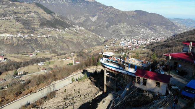 15 metre uzunluunda, 4.60 metre geniliindeki tekneyi denizden Akaabat ilesine getiren Zafer tekneyi vin yardmyla TIR'a ykledi. Tek eritli, rampal ve virajl yollardan geilerek iledeki 661 rakml Yenimahalle?ye getirilen tekne, daha nceden yaplm beton yapnn zerine yerletirildi.