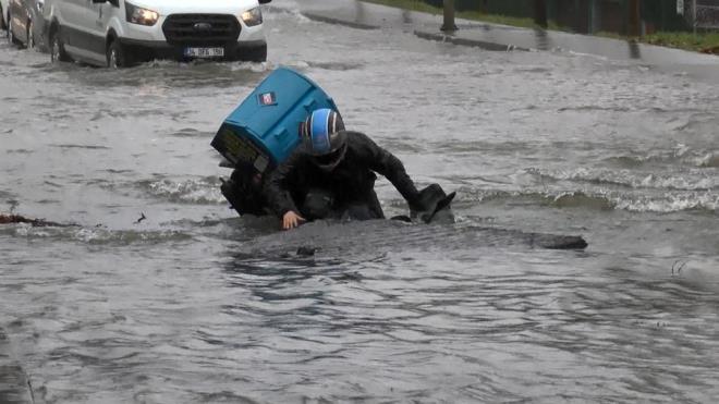 MOTO KURYE UKURA DT  Cadde zerinde biriken sularda ilerlemeye alan bir moto kurye patlama nedeniyle oluan ukura dt.