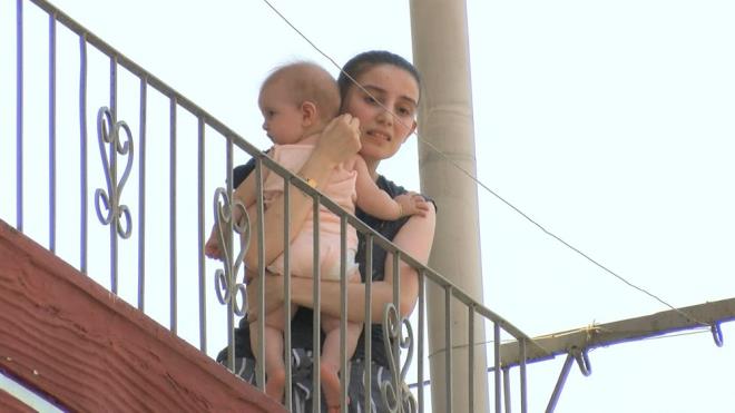 Bir kadnn ocuunu kucana alarak korku iinde balkonda bekledii grld.