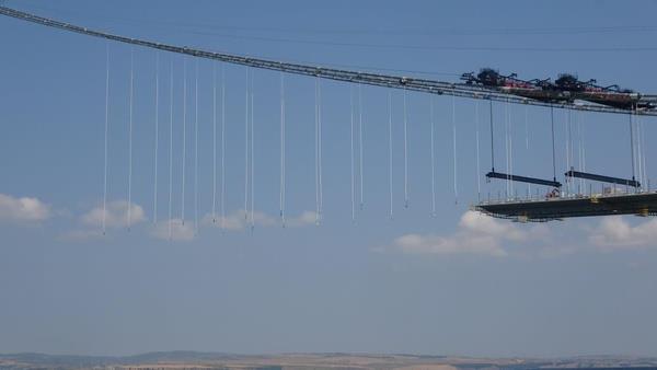 Seyit Onba tasviri de yer alacak<br>  Kulelerin en ucunda ise anakkale Savalarnn unutulmaz kahraman Seyit Onba?nn srtlayarak namluya srd top mermisi tasviri yer alacak. 1915 anakkale Kprs?nn Cumhuriyet?in kuruluunun 100?nc yln temsilen orta aklnn 2023 metre olmas planlanyor. Bu aklk, dnyann en yksek kuleler aras akla sahip asma kpr olmas zelliini tayor. Kpr hizmete aldktan sonra iki yaka arasndaki ulam mesafesi 6 dakikaya inecek. Kprnn blgeye de ciddi faydalar salayaca ve zellikle Lapseki?ye yatrmc talebinin artaca ngrlyor.