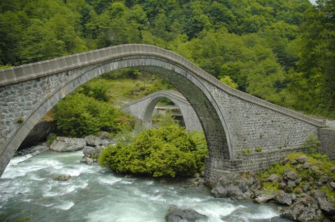 FTE KPRLER     Artvin'in Arhavi ilesinde yer alan ve birbirini tamamlayarak tam daire zellii tayan tarihi "ifte Kprler", asrlara meydan okuyan ihtiaml grntsyle grlmeye deer yerler arasnda. Ziyaretelerin her mevsim youn ilgi gsterdii bu tarihi kpr, kentin en nemli kltrel yaplar arasnda gsteriliyor. leye Bal Ortacalar blgesinde Kamilat ve Soucak dereleri zerinde birbirini tamamlayayarak konumlandrlan kprler, 18. yzylda moloz ve kesme talarla Osmanl mimarisi eklinde ina edilmi ve yllar nce restore edilerek turizme kazandrld. Yemyeil doas ve gz alc mimarisiyle grlmeye deer ifte Kprler?i rotanza eklemeyi unutmayn.