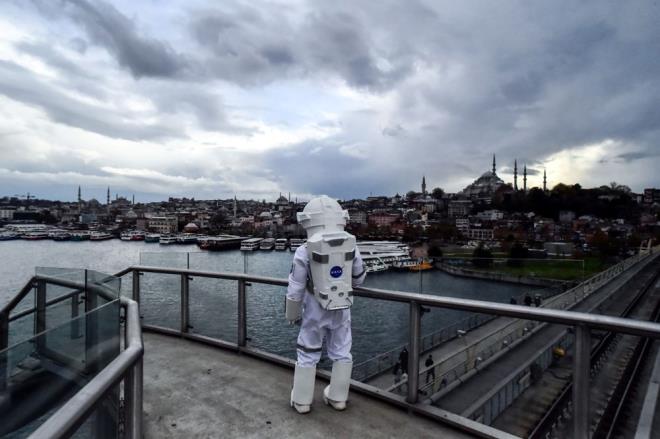 M2 Yenikap-Hacosman metro hattndaki birok durakta mola da veren astronot, Hali duranda inerek stanbul'un tarihi manzarasn izledi.