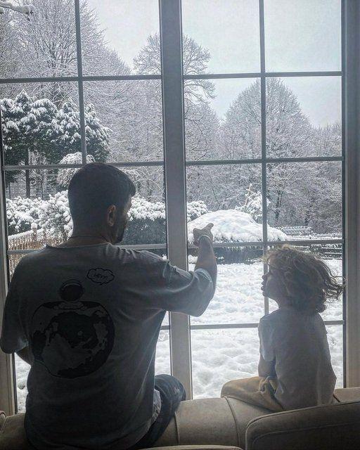 Ceyda Dvenci ile mutlu bir evlilik srdren oyuncu Blent akrak da olu Ali ile birlikte evde camdan dar bakarken ekilen bu fotoraf yaynlad.