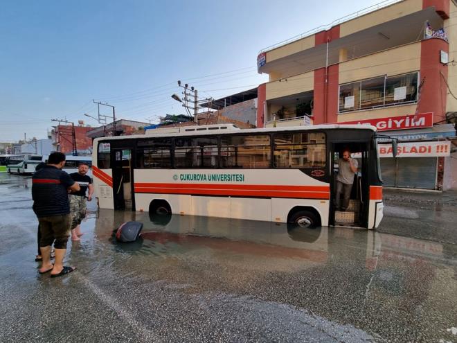 Mustafa Ayhan Ball ynetimindeki 01 J 0218 plakal zel halk otobs, asfaltn kmesi sonucu oluan ii su dolu ukura dt. Dier aralar, ukurda mahsur kalan otobsn etrafndan gemeye devam etti.