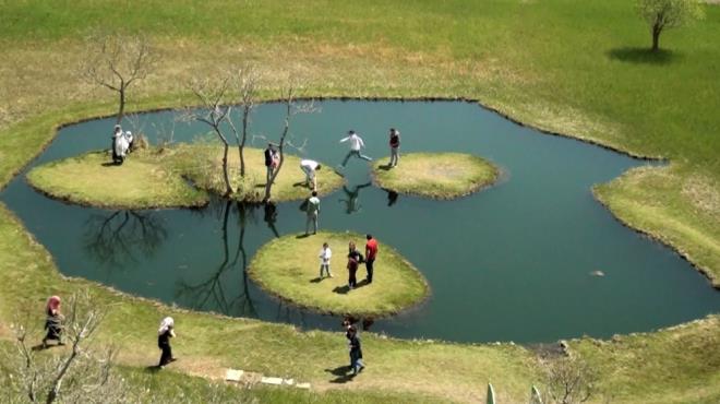 Ellerindeki uzun sopalarla bekleyenlerin yzen adalar ynlendirmesiyle baz ziyaretiler ile gelin ve damatlar, belli cretlerle zerine kp fotoraf ektiriyor.