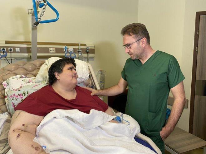 "LK BATAK KLONUN YAKLAIK 3-4 KATINA KADAR IKIYOR"    Hastasnn durumu ve uygulanan tedaviye ilikin aklamalarda bulunan Prof. Dr. Mehmet Karabulut, "Hastamz daha nce sper morbit obez deildi, hafif bir kilosu mevcuttu. Daha sonra bu kilodan kurtulmak iin hastamz bir aray iine giriyor. nternetten aratryor, internetten bitkisel ila temin ediyor. la kullandktan sonra kas iskelet sisteminde atrofi, fel geliiyor ve yataa baml hale geliyor. Yataa baml olunca aslnda bir ksr dng oluuyor. Hareket edemeyince daha fazla kilo alyor ve ilk bataki kilonun yaklak 3-4 katna kadar kyor. Bundan sonra hem ar kilo alyor hem de kiisel hijyenik sorunlar da balyor ve yataa baml bir ekilde dnemez hale geliyor. Daha sonra hastamz kurtulmak istiyor, obezite ameliyat yapan eitli merkezlere bavuruyor. Onlardan da zm olmaynca devletimize, Salk Bakanl'na bavuruyor. Ameliyat ncesi btn hazrlklar yaptktan sonra ameliyat karar aldk. Hastamza tp mide ameliyat gerekletirdik. Ameliyattan sonra da youn bakmn, anestezi destekleriyle beraber hasta u an gayet iyi durumda." eklinde konutu.