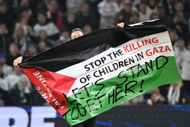 �zerinde "Gazze'deki �ocuklar� �ld�rmeye son verin", "Birlikte dural�m" yazan Filistin bayra��yla sahada tur atan taraftar, stat g�revlilerinin m�dahalesiyle d��ar� ��kar�ld�.