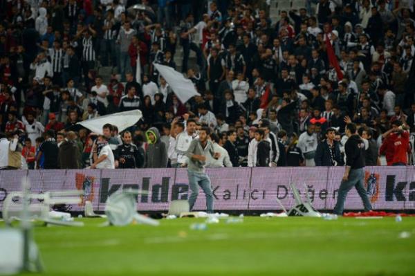 <b>GLOBALPOST:</b> Y�ksek profilli Be�ikta�-Galatasaray derbisi taraftarlar�n sahay� i�gali �zerine ma� durduruldu. Taraftarlar sahaya ve polislere koltuklar f�rlatt�.