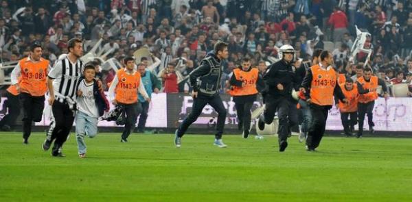 <b>L'EQU�PE:</b> Be�ikta�'�n rekor seyirci deste�i kaosla bitti. �stanbul derbisinde Melo'nun k�rm�z� kart g�rmesinin ard�ndan Be�ikta� taraftar� sahay� i�gal etti. Hakemler ve oyuncular soyunma odas�na girerken saha i�i kar��t�. Ma��n nas�l sonu�land��� belli de�il.