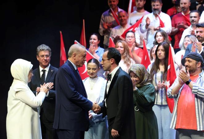 Sahneye kan Erdoan iftine ehit mer Halisdemir'in olu Erturul Halisdemir ile dnemin Terrle Mcadele Daire Bakan Turgut Aslan tarafndan iek takdim edildi..