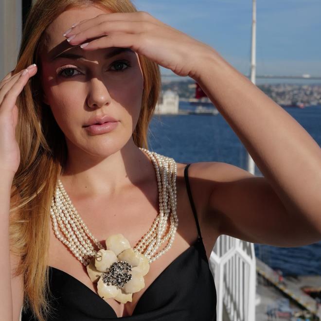 <strong>Yazn Enerjisi ve klk</strong><br>  Meryem Uzerli siyah saten elbisesi, zarif incilerden oluan byk iek kolyesiyle yazn enerjisini ve sofistike stilini yanstyor.