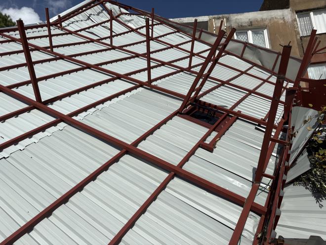 <b data-path-to-node="4" data-index-in-node="9">Metal �at� Havada Savrularak Binalara �arpt�</b>  Yerinden s�k�len dev metal �at�, r�zgar�n etkisiyle bo� araziye ve evlerin bulundu�u alana do�ru savruldu. �at� par�alar� �evredeki binalar�n d�� cephelerine �arparak durabildi, sokakta kimsenin olmamas� muhtemel bir faciay� �nledi.