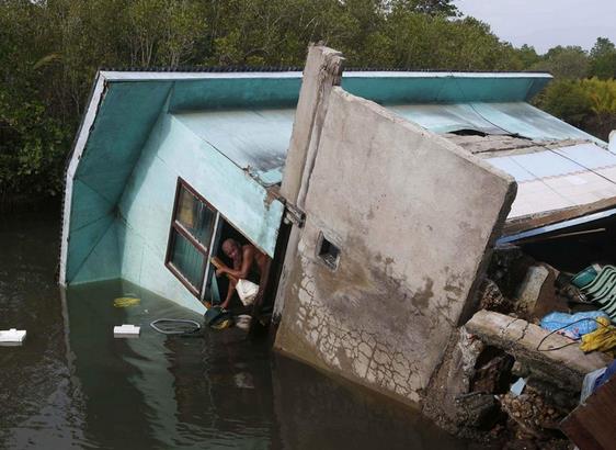 Filipinler'deki 7,2 byklndeki depremle birlikte evi bitiiindeki nehre doru yklan bir adam, salam kalan eyalarn kurtarmaya alyor.    <p><b<Filipinler</b></p>