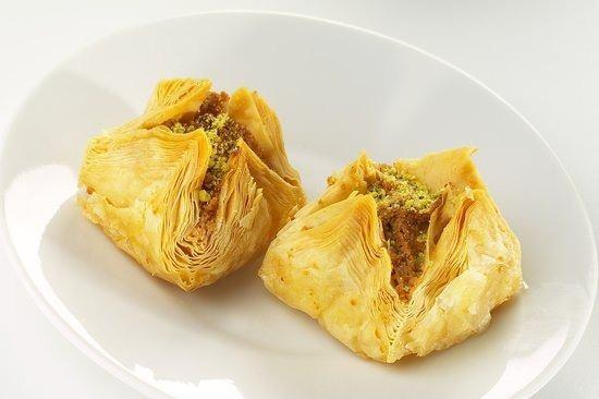 <p><span style="color:#FF0000"><strong>13. BUKAJ BAKLAVA / L�BNAN&nbsp;</strong></span></p>    <p><strong>Ad�, Arap�a bukjah kelimesinden gelen Bukaj baklavas�, ismiyle bir kuma� par�as�ndan paket yapma gelene�ine at�fta bulunur. Bu lezzet, geleneksel olarak f�st�k veya �am f�st��� ve kaju f�st��� kar���m�yla doldurularak kat kat dikd�rtgen yufka hamurundan olu�maktad�r.</strong></p>