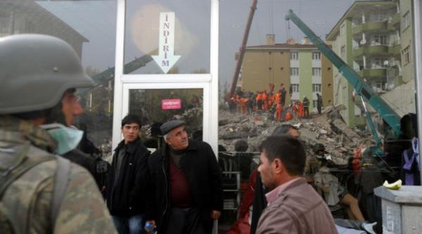 ken bir binadaki kurtarma almalarn seyreden erkekler. (26 Ekim 2011)