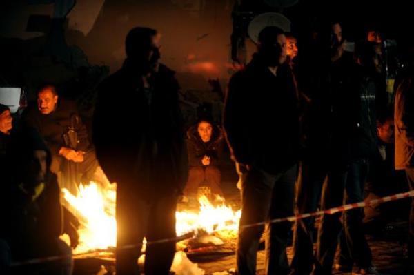 Yklan binalarn arasndaki atein etrafnda bekleyen depremzedeler (29 Ekim 2011)