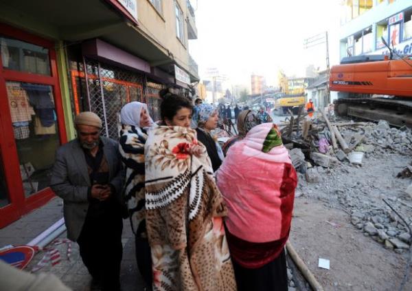 Kurtarma ekipleri enkaz altndakileri kurtarmaya alrken lenlerin yaknlar almalar seyrediyor. (24 Ekim 2011)